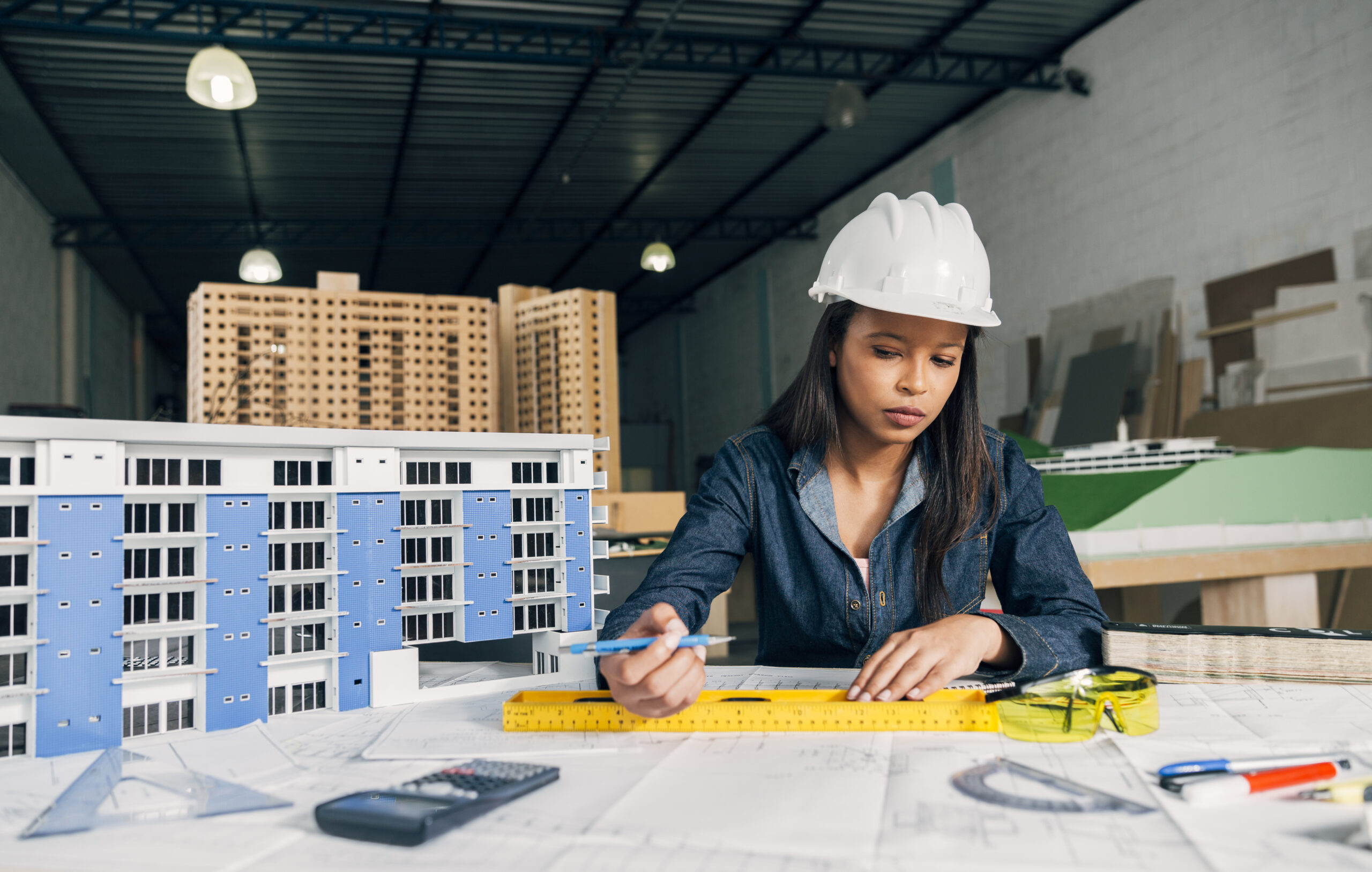 African american woman safety helmet working near model building